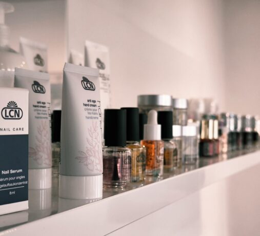 Auswahl an professionellen LCN Nagelpflegeprodukten, Seren und Handcremes auf einem weißen Regal im Nageltraum Studio.